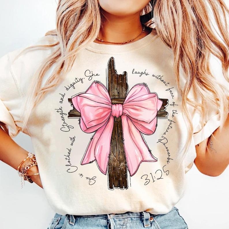 Proverbs She is Clothed with Strength Coquette Bow Light Pink Shirt, Preppy Design, Coquette Bow, Bible Verse, Christian Girls, Cotton, Crewneck, Graphic Tee